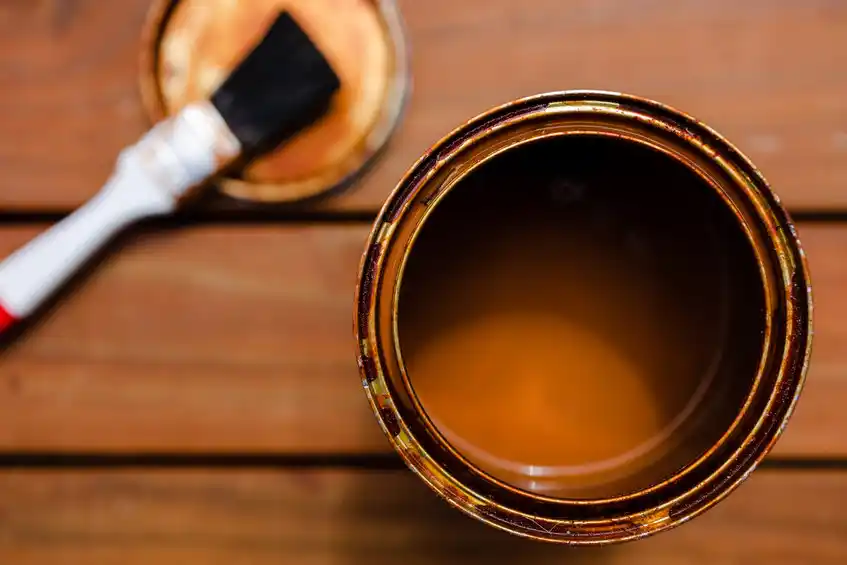 Bucket of wood stain and brush